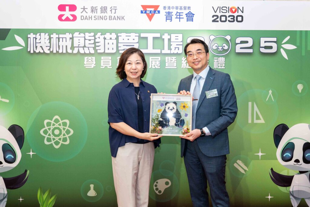 香港中華基督教青年會署理總幹事黃宗義先生(右)向大新銀行副行政總裁、高級執行董事兼集團個人銀行主管王美珍女士(左)致贈一個呼應本次計劃主題的「熊貓乾花紀念品」,以表達對大新銀行全力支持的誠摯感謝。