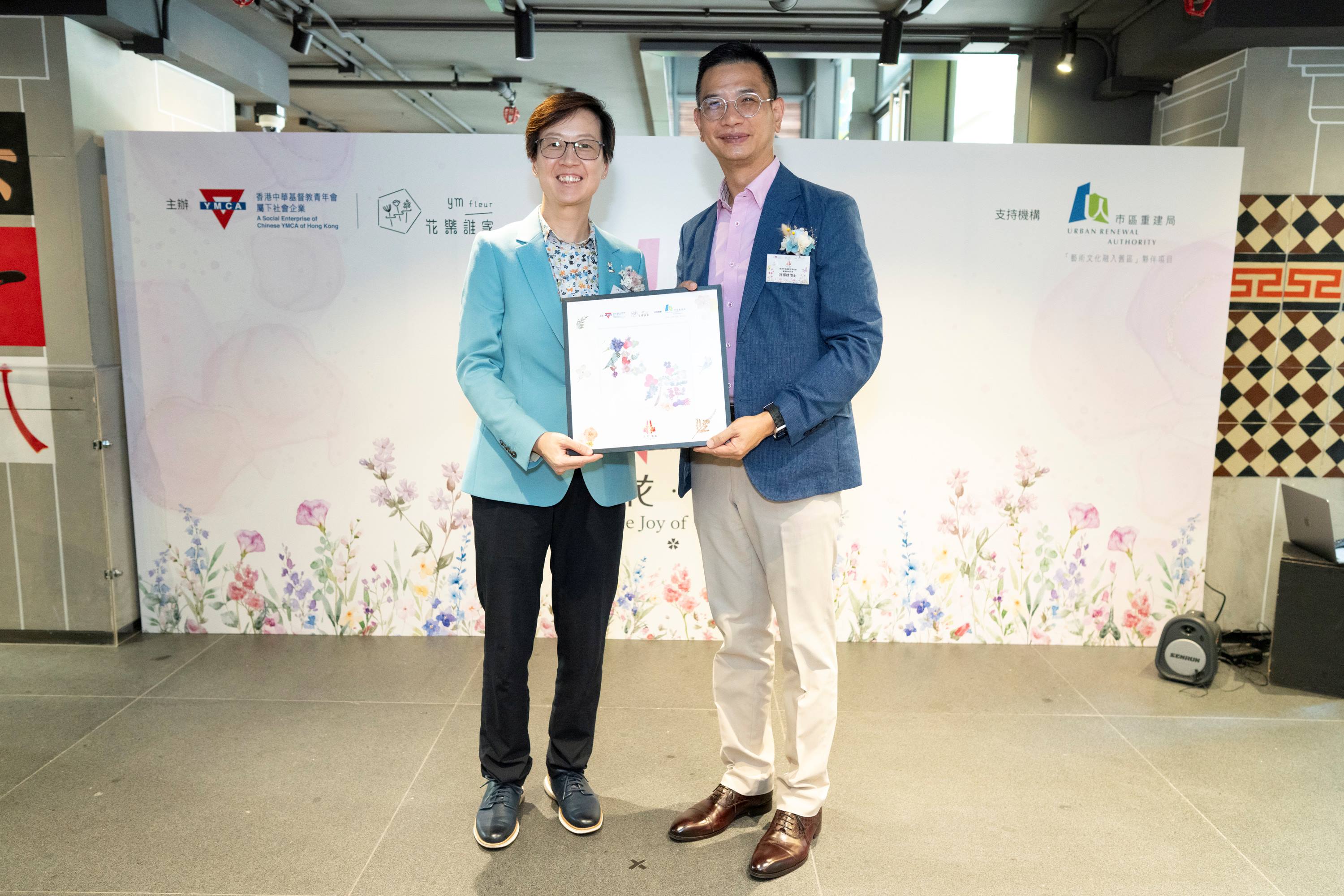 香港中華基督教青年會署理副總幹事許繹標博士(右)致送紀念品給市區重建局社區發展總經理陳碧霞女士。