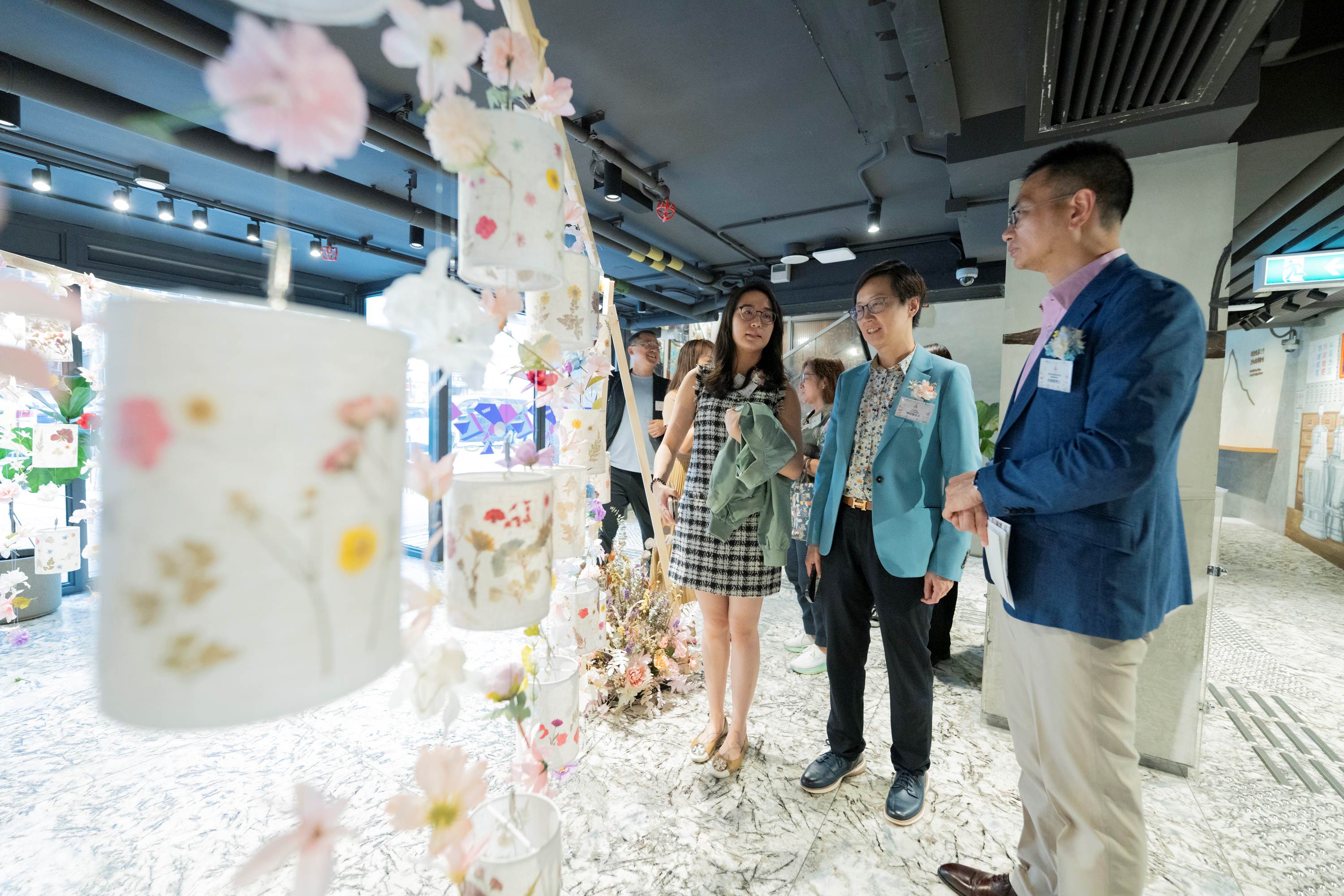 主禮嘉賓一同欣賞太子區居民製作的花藝品。（左起：油尖旺民政事務助理專員黃思齊女士、市區重建局社區發展總經理陳碧霞女士 、香港中華基督教青年會署理副總幹事許繹標博士）